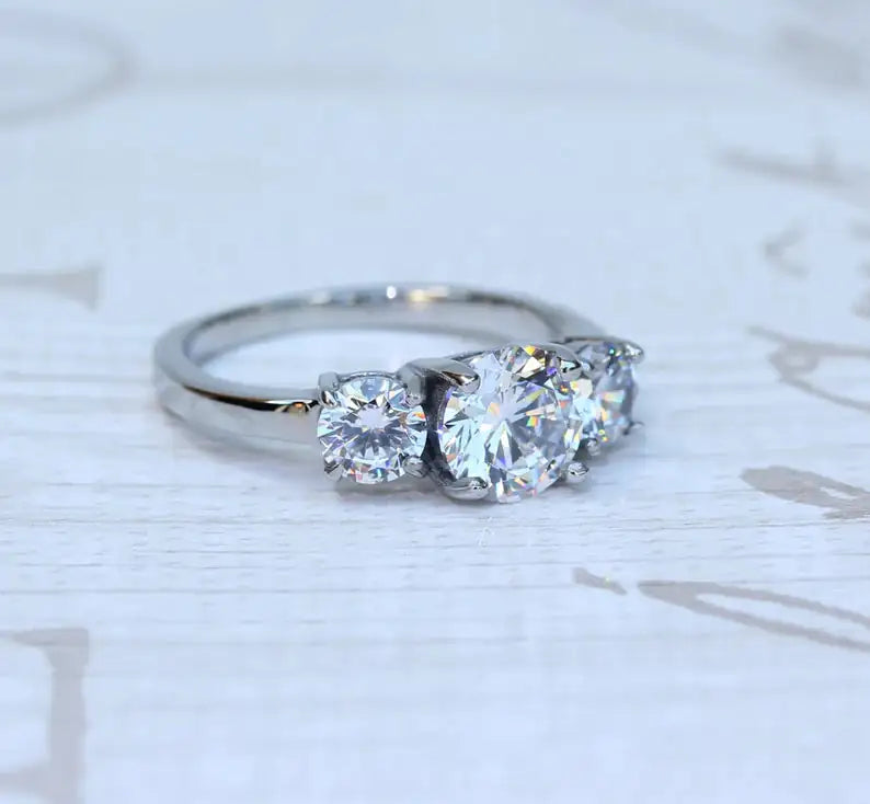 Side view of 925 sterling silver three-stone CZ ring — prong setting, adjustable band