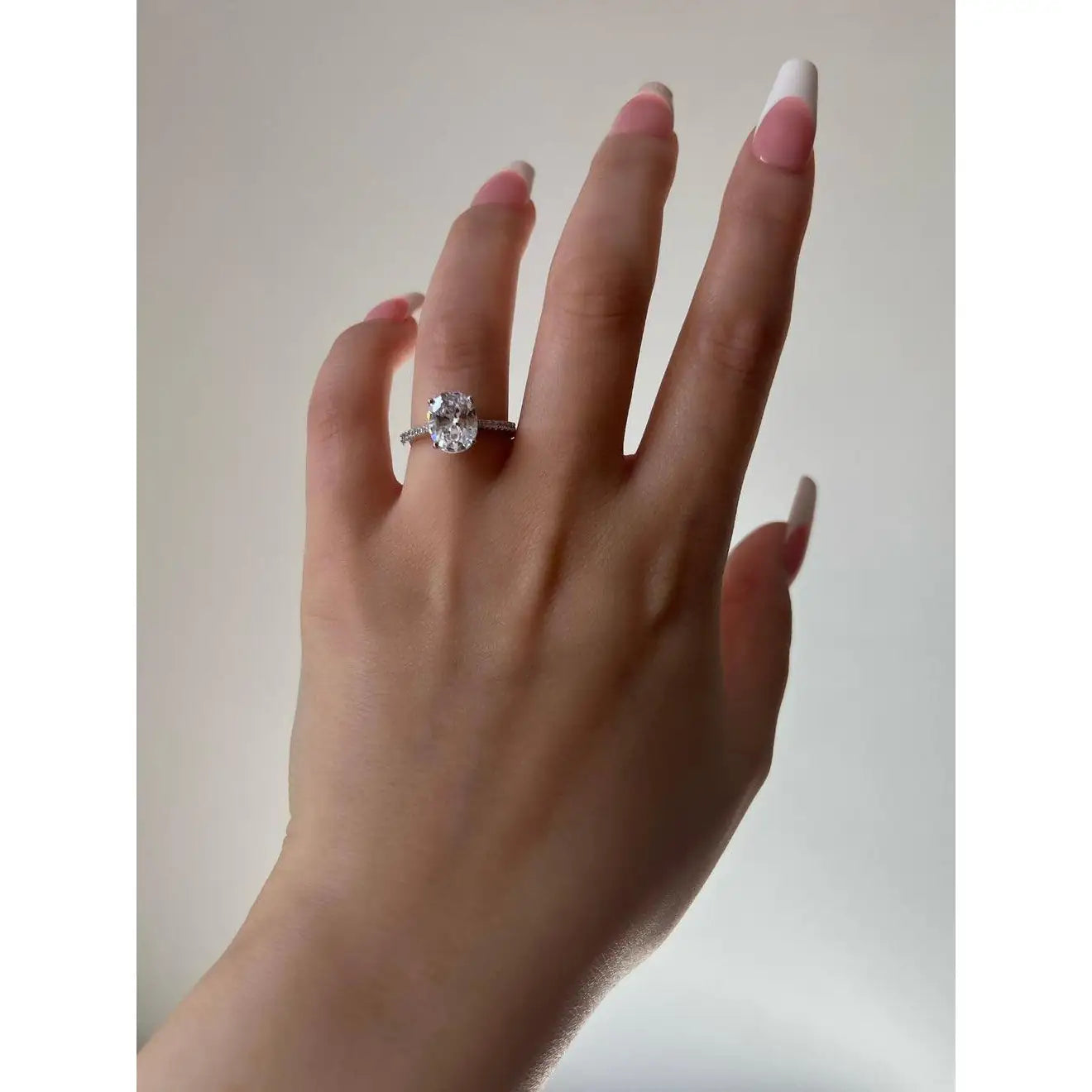 Side profile of Serenade 925 silver oval ring — prong-set CZ stone, polished rhodium finish