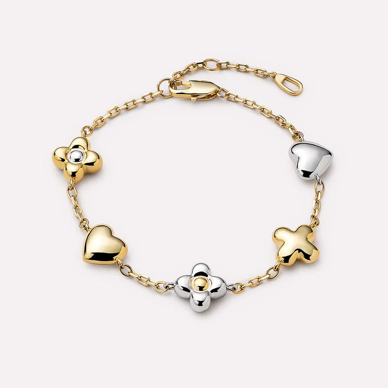 Gold and silver bracelet with heart and clover designs on a white background