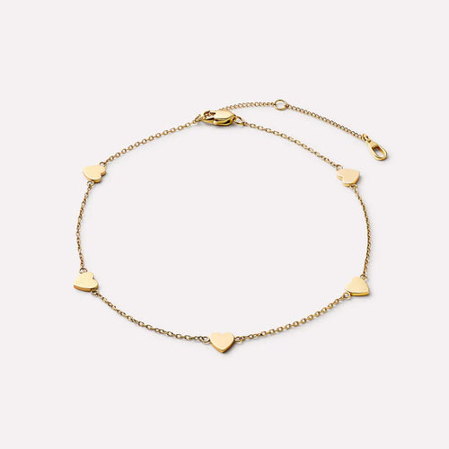 Gold bracelet with heart-shaped charms on a light beige background