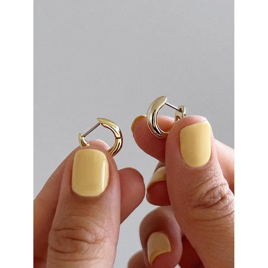 Woman wearing Echo gold plated sterling silver hoop earrings — classic 925 silver hoops, everyday wear